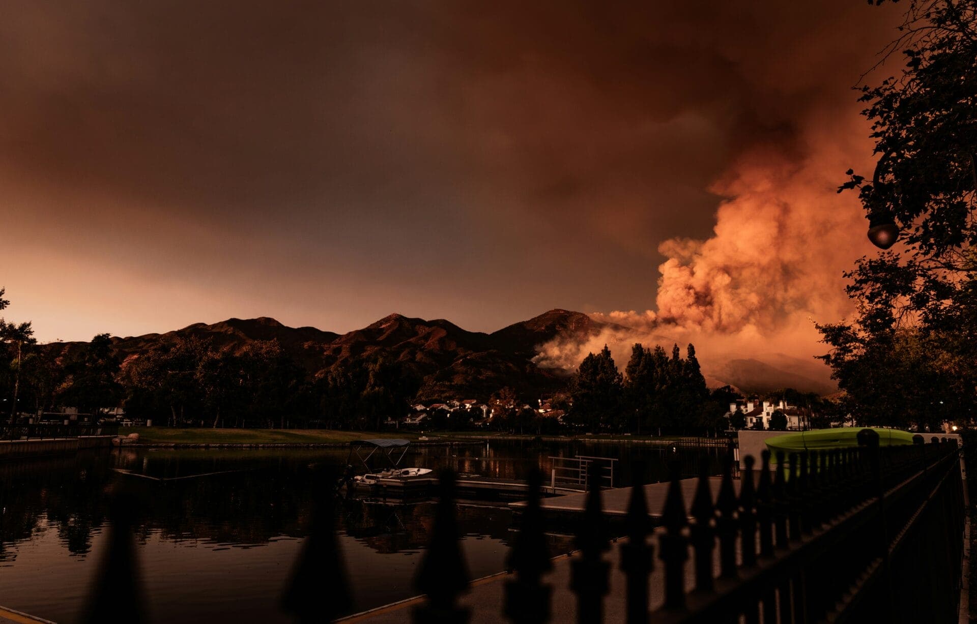 Wildfire smoke rising over a lakeside community